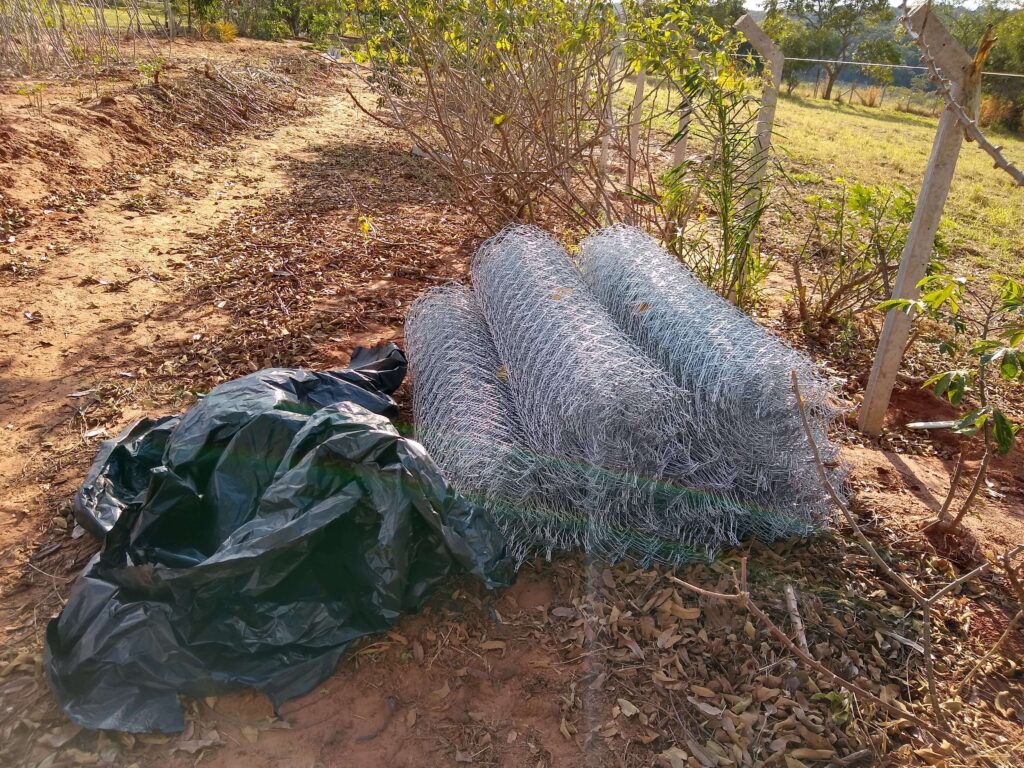 Empilhamento de rolos de alambrado, representando os materiais prontos para a construção da cerca.