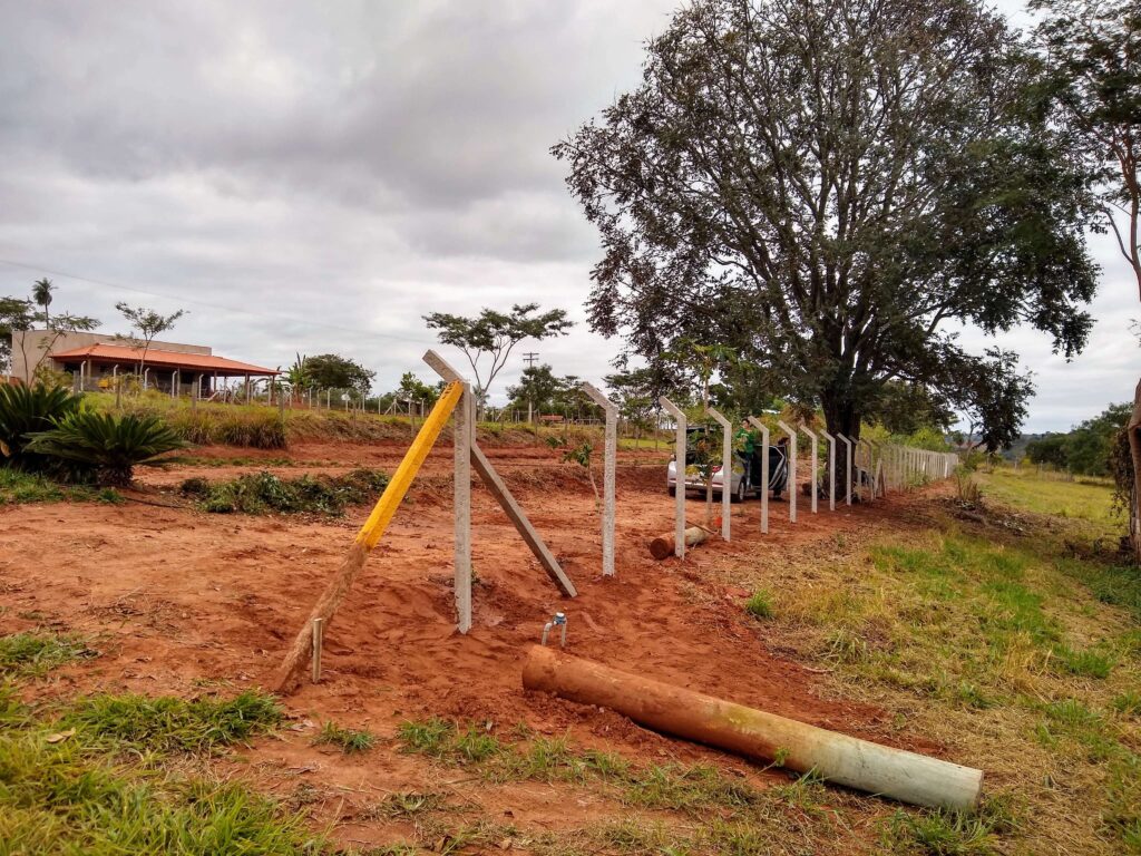 Pilares firmemente fixados ao solo durante a construção do alambrado, representando um estágio crucial no processo de instalação.