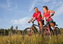 Homem e mulher felizes praticando ciclismo em trilha natural