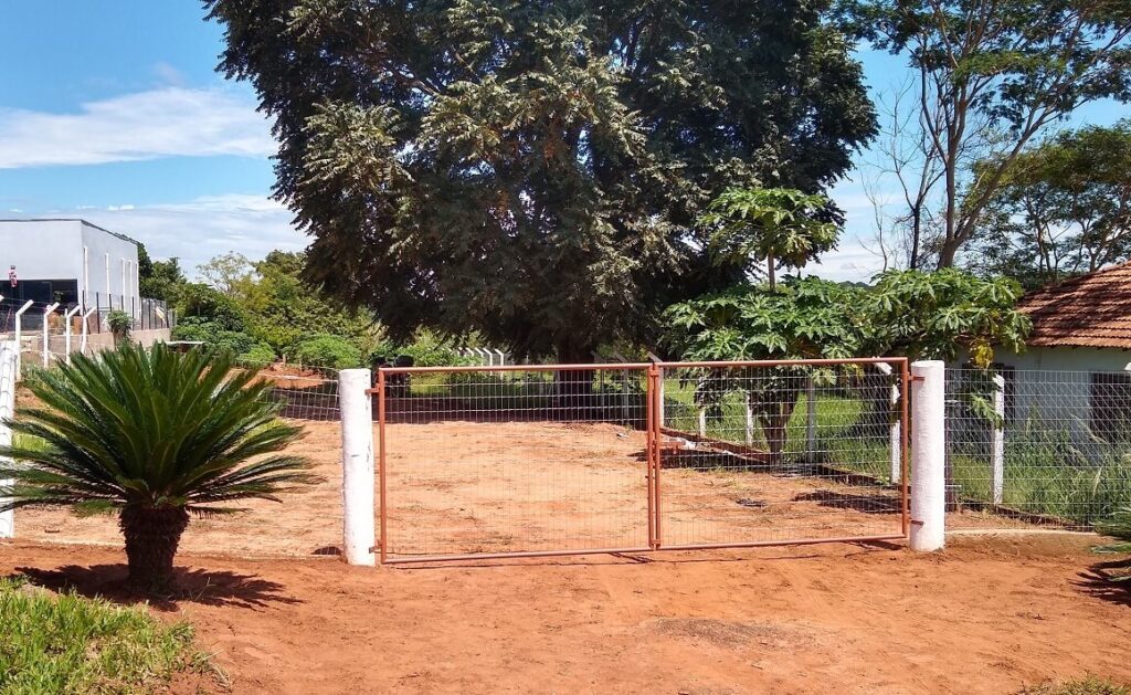 Portão de entrada simples, mas seguro, que oferece proteção e tranquilidade à chácara.