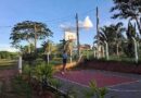 Adolescente faz uma cesta na quadra de basquete, demonstrando seu amor pelo esporte.