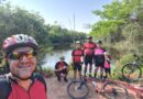 Integrantes do Grupo Baixa Pressão fazem uma selfie sorridente em frente à deslumbrante Lagoa do Bezerrão, celebrando sua jornada na Trilha do Bezerrão.