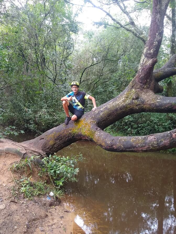 João Pedro, adolescente de 15 anos, escalando uma árvore na Trilha dos 3 Rios em Bauru.